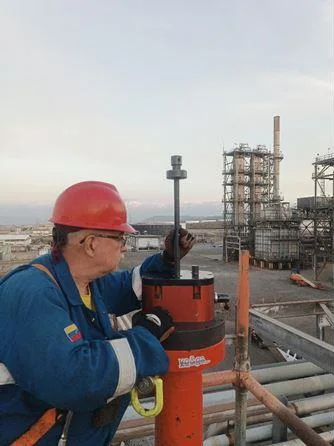 Técnico operando maquinaria de hot tapping en una instalación industrial